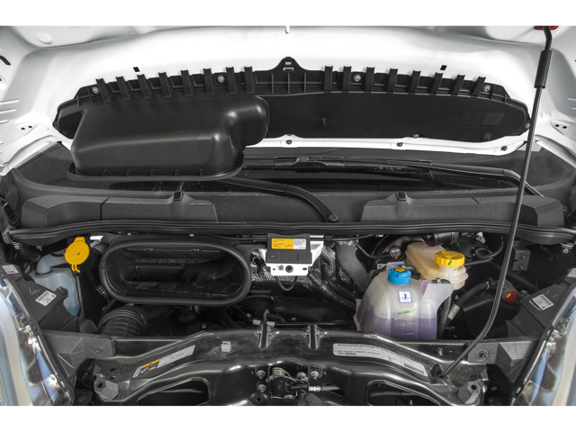 Engine bay of a cargo van showing intake system, coolant reservoir