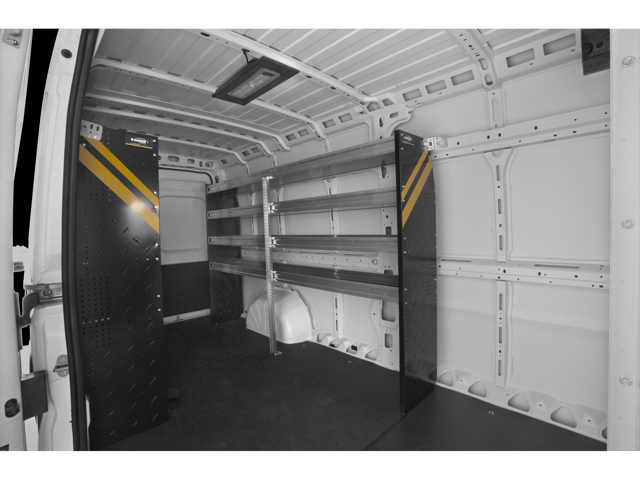 Cargo van interior fitted with metal shelving units along the side wall and reinforced flooring