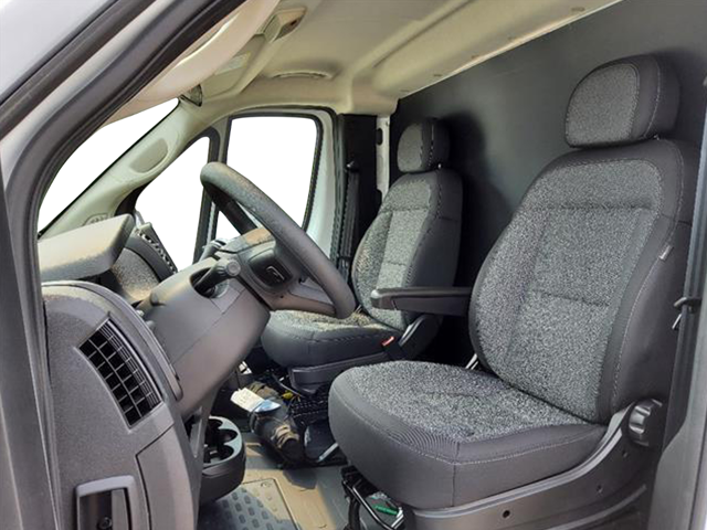 Front seating view of truck cab with fabric seat, steering wheel