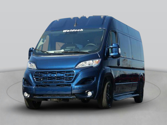 Front three-quarter view of a dark blue high-roof van with large grille