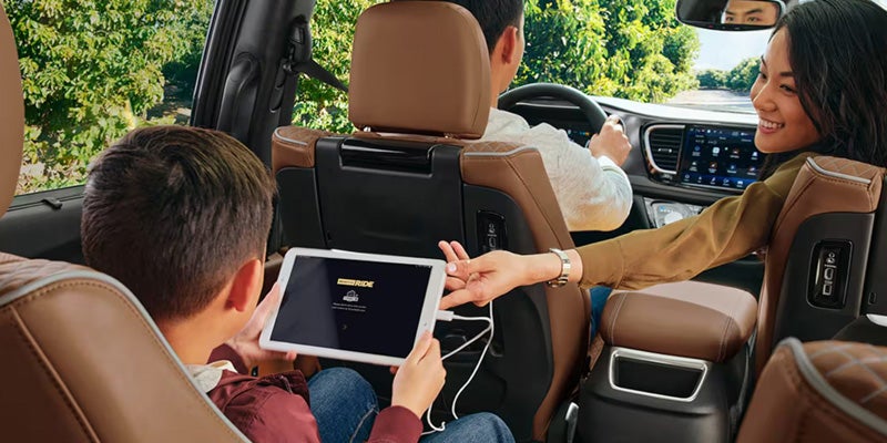 Rear seat passengers in a minivan using a tablet entertainment system while