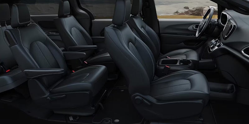Minivan interior showing three rows of black leather seats
