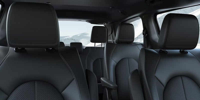 Minivan interior showing multiple rows of black seats