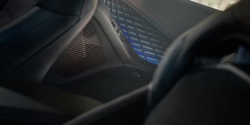 Close-up of car interior door panel with blue ambient lighting accents