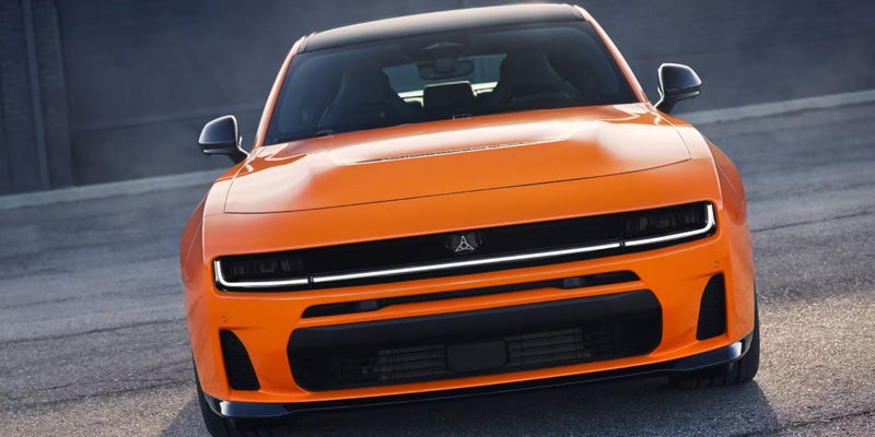 Front view of an orange sports sedan with a wide grille, slim headlights