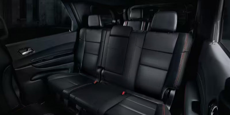 Rear seating area with black leather seats, headrests, and spacious legroom inside an SUV