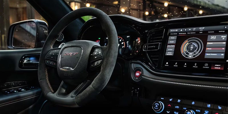 Driver cockpit showing steering wheel with performance badge