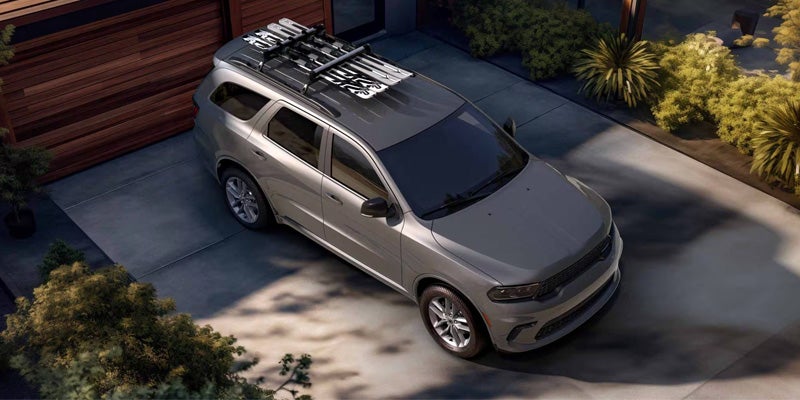 Light-colored SUV parked in a driveway beside a house