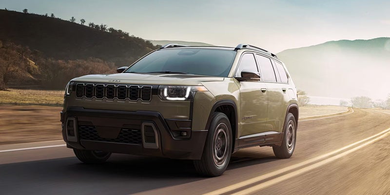SUV driving on a paved road through countryside scenery