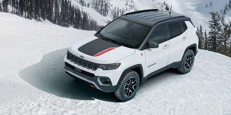 White SUV parked on snow-covered ground, shown from above