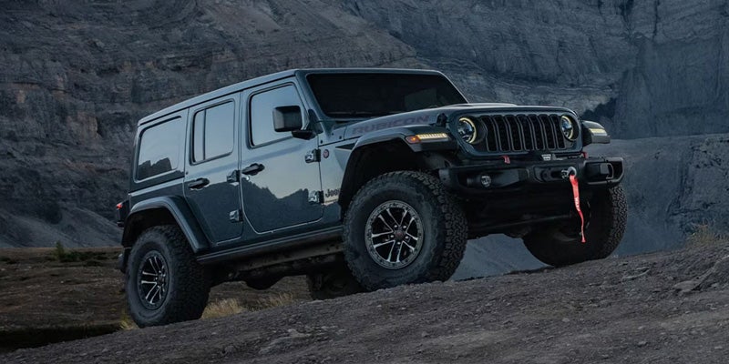 The SUV is captured in a rocky, mountainous terrain, likely off-road