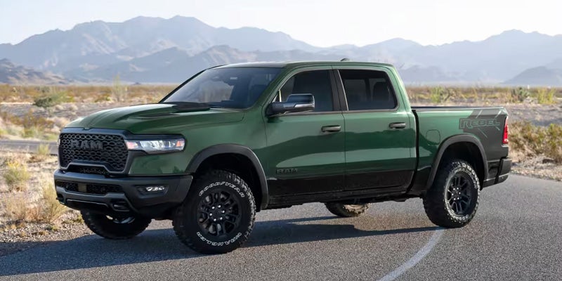 A dark green RAM pickup truck is parked on a paved road