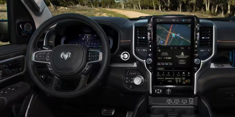 Interior view of a RAM truck showing steering wheel, digital instrument cluster