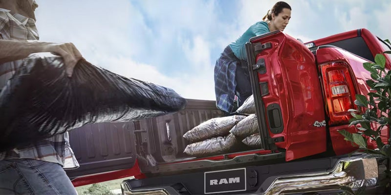 Open bed of a red RAM pickup truck being loaded