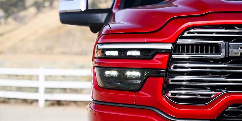 Close-up of the front grille and headlights of a red RAM truck