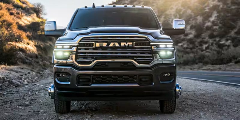 Front view of a RAM truck parked on dirt ground
