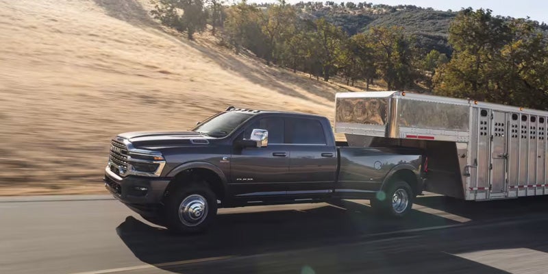 Black RAM heavy-duty pickup truck towing a large RV trailer